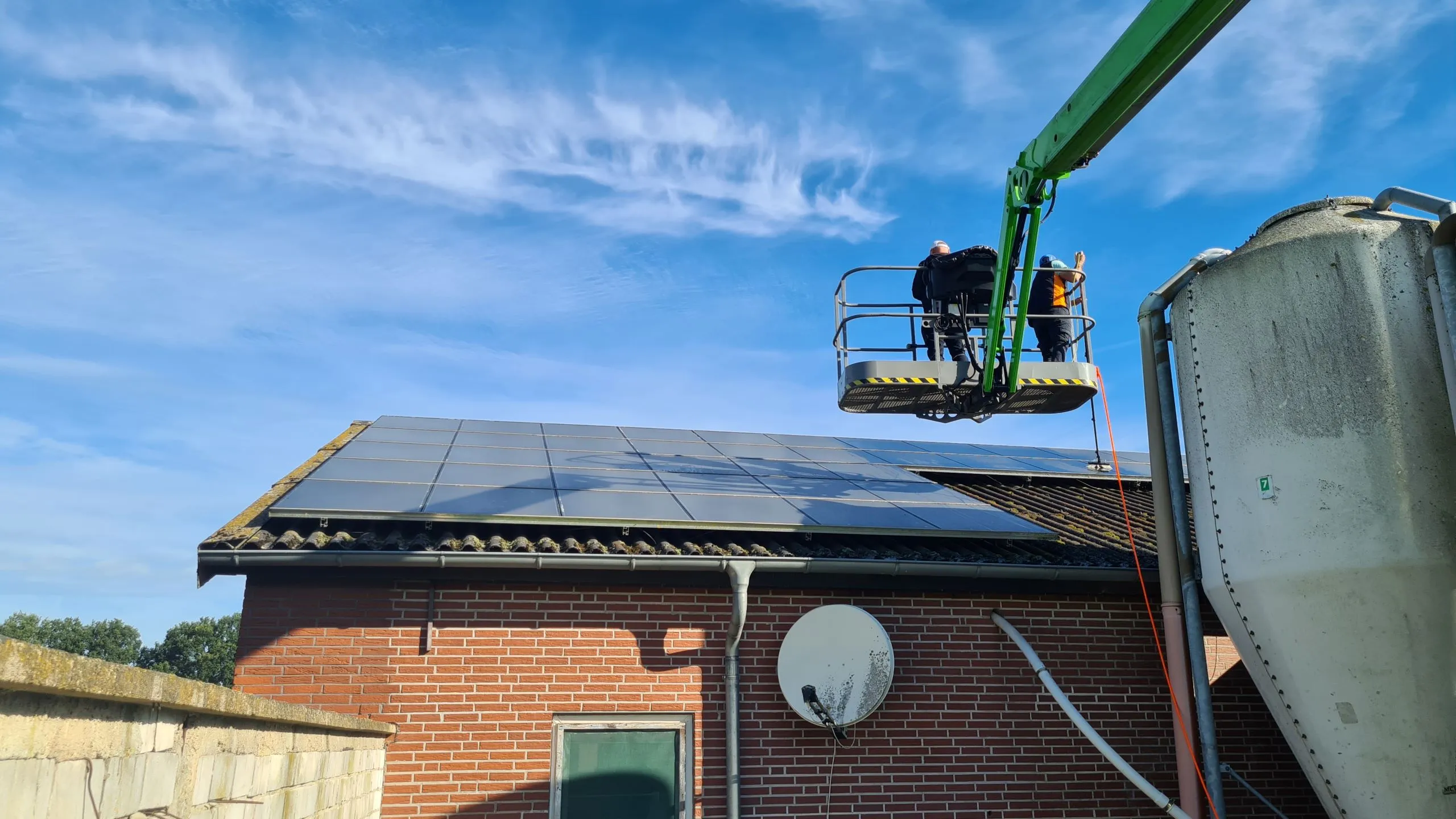 Reinigung einer Photovoltaikanlage auf einem Stalldach vom Hubsteiger aus