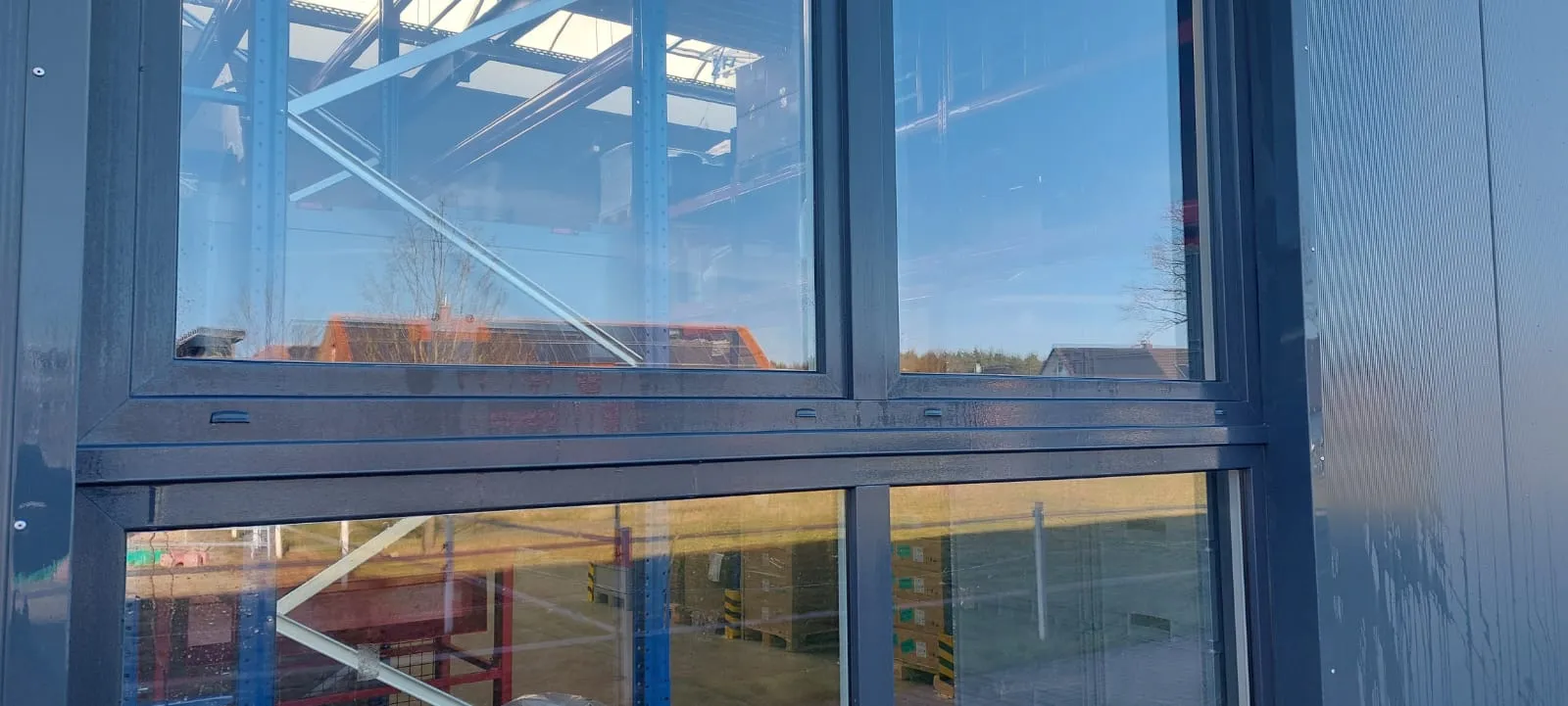 Fensterband einer neuen Gewerbehalle mit Gerüst im Hintergrund